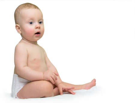 8 month boy sitting on sofa, on white background.の写真素材