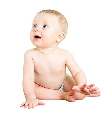 Eight month boy sitting on sofa, and looking up, on white background.の写真素材