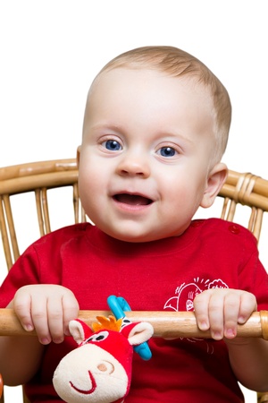 8 month boy sitting on a wicker chair, isolated on white.の写真素材