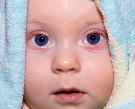 Portrait of 6-months old baby boy in towel.の写真素材