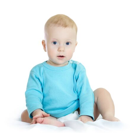 Eight month boy in blue t-shirt sitting, on white background の写真素材