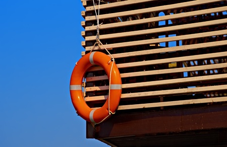 Lifebuoy on a wooden plank wall against blue skyの写真素材