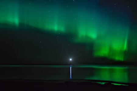 Night landscape with Aurora Borealis over the Ladoga Lake and a lighthouseの写真素材