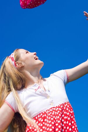 Expressive young girl on blue sky backgroundの写真素材