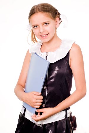Smiling pretty schoolgirl in dress holding a fileの写真素材