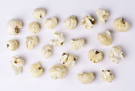 Popcorn grains spilted on white backgroundの写真素材