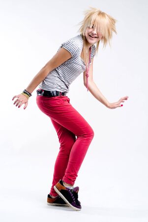 Funky teenage blonde emo girl dancing at white backgroundの写真素材