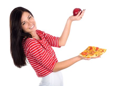 Cute brunette juggles with apple and piece of pizzaの写真素材