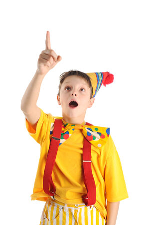 Surprised pointing up boy dressed like a clownの写真素材