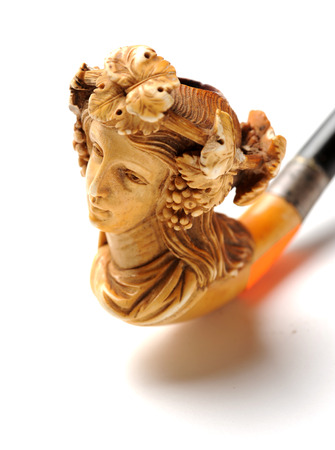 Antique elegant carved pipe closeup at white の写真素材
