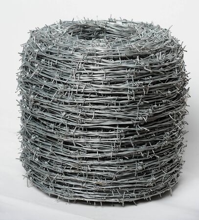 Roll of twisted barbed wire at white backgroundの写真素材