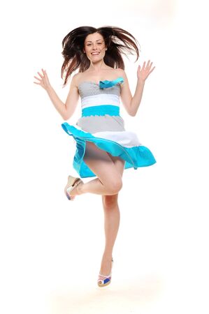 Beautiful excited jumping girl in summer dressの写真素材
