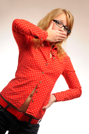 Pretty girl posing closing her mouth with handの写真素材