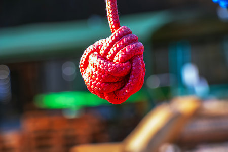 Close up of rope knot on children's playground in public park. Redの写真素材