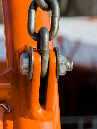 Close up of bolt fastener with washers and nuts with chain. Vertical.