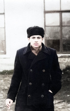 Vintage portrait of attractive young man in cap with cigarette. Retro photo from 1957.