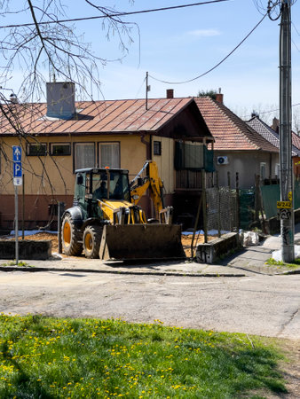 Excavator or backhoe loader near construction site near house in Nitra, Slovakia.の写真素材