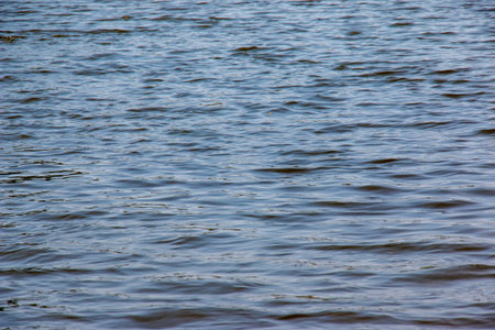 Background of Dnieper River water surface with ripples. Natural color of river water. Water with...