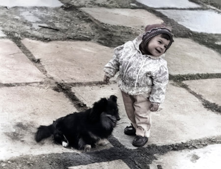 Vintage portrait of a cute little girl who is happy to see a dog. Retro photo from 1995.の写真素材