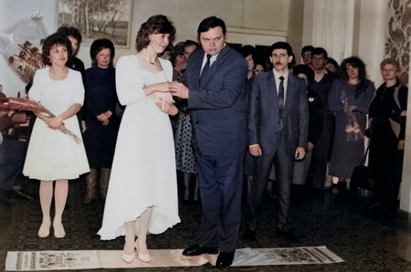 Dnipropetrovsk, Ukraine - March 6, 1993: A vintage portrait of the bride and groom with friends at a wedding ceremony in the registry office. Retro photo.のeditorial素材