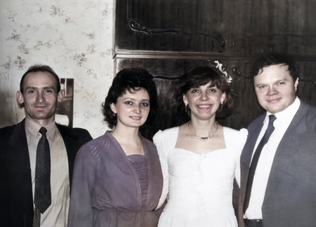 Dnipropetrovsk, Ukraine - March 6, 1993: A vintage portrait of the bride and groom with friends at a party after the wedding ceremony at the registry office at the groom's home. Retro photo.のeditorial素材