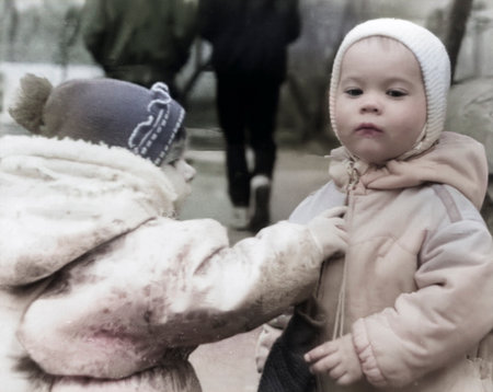 Dnipropetrovsk, Ukraine - April 15, 1995: Vintage portrait of two young children on a walk in the park. Retro photo.のeditorial素材