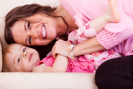 smiling happy mother and children lying on sofaの写真素材