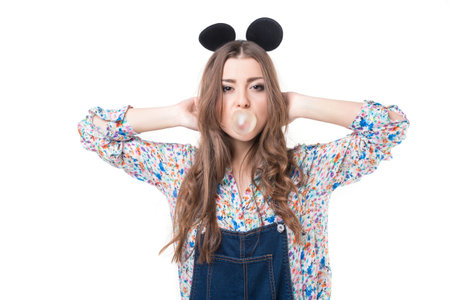 Beautiful girl posing in studio. Blow bubble gum