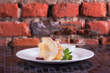 Pancakes with butter and berries cranberry decorated mint on tableの写真素材