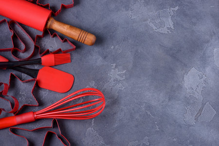 Red shapes pastry cutters and kitchen utensols with copy space for recipe