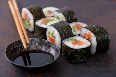 Close-up sushi roll with soy sauce.  Asian food on brown backgroundの写真素材