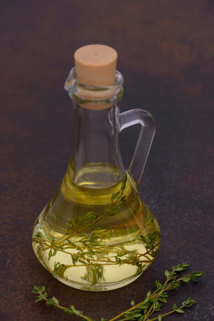 Bottle with olive oil and thyme. On dark backgroundの写真素材