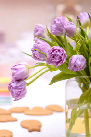 Close-up purple tulips in vase on table, template card greetingsの写真素材