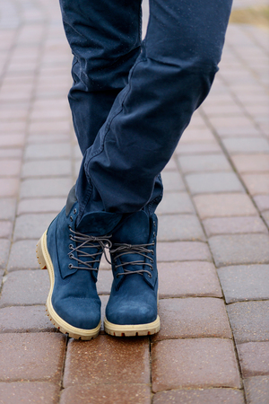 Blue boots on men's legs in blue jeans outdoorの写真素材