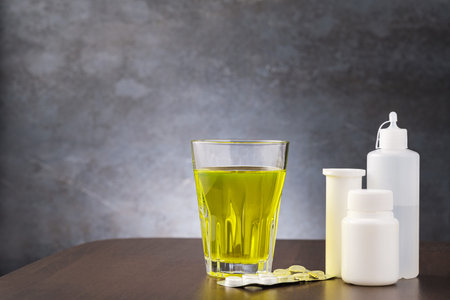 Glass with medicine and jars with pill and tablet with copy space