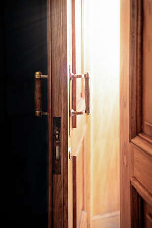 old wooden thick door opens, bright sunlight illuminates the doorway, the concept of new ideas, future, success and happiness, paradiseの写真素材