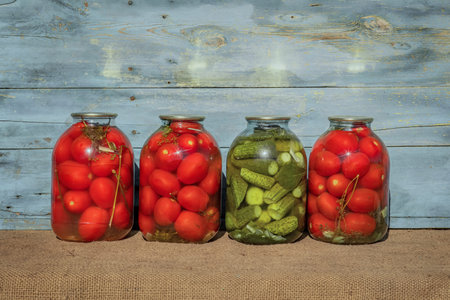 pickle tomatoes and cucumbers, homemade recipes, glass jars with vegetables, harvest seasonの写真素材