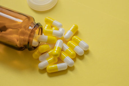 medicine capsules on yellow background, pill bottle, dietary supplements