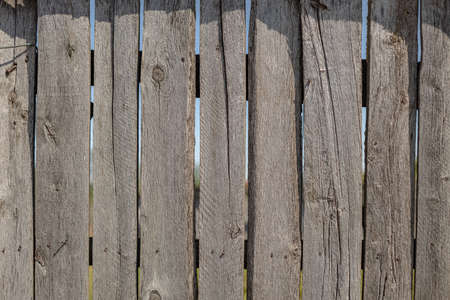 fence made of old wooden boards, texture of old, cracked boards, wooden backgroundの写真素材