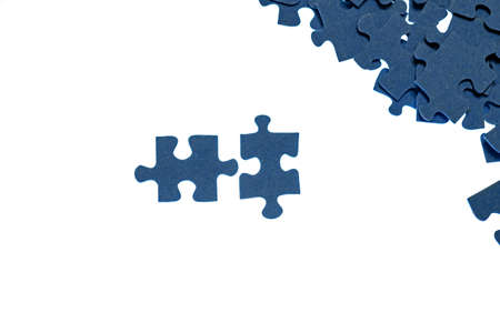 small blue puzzle pieces on a white background, add a picture from small pieces, a useful exercise for the brain, training attention and patienceの写真素材