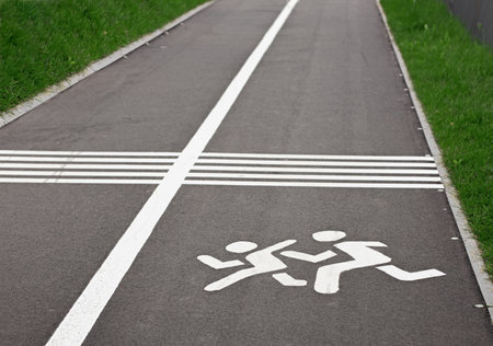asphalt road with white stripes, white sign painted on the road, warning pavement signの写真素材
