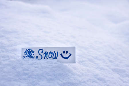 fresh white fluffy snow, snowdrift on the street, inscription snow on a piece of paper, snowflake pattern, snow texture in winter seasonの写真素材