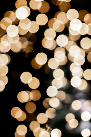 blurred golden lights on dark background, christmas bokeh from christmas garlandの写真素材