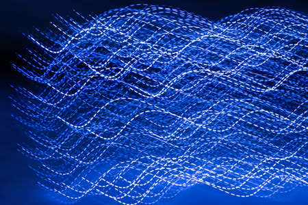 blue light waves, photo of neon blue lines in an abstract swirl. Long exposure photography, concept of chaos, movement, speedの写真素材