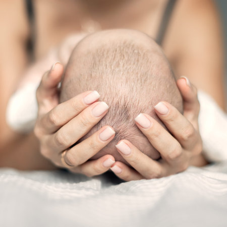 mother holds the baby's head in her hands, mother's day, happy moments of motherhood