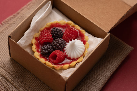 food delivery, sweet dessert with fresh berries in a cardboard box, fresh baked goods to take awayの写真素材