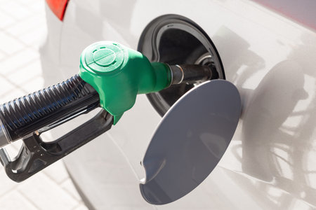 refueling a car with a green nozzle at a gas station, Transport and industry concept. Gas pump