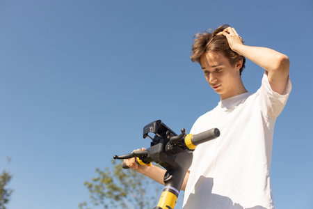 Young man using smartphone for electric scooter rentの写真素材