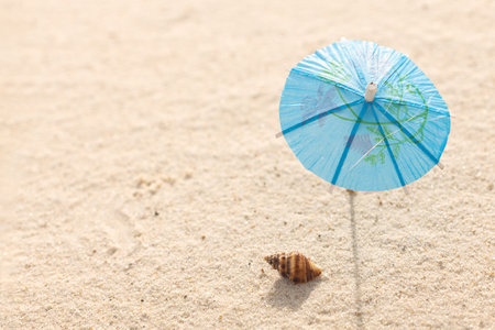 Miniature beach with umbrella or parasol on tropical islands sand. Tropical resort and vacation concept. Free space for your textの写真素材