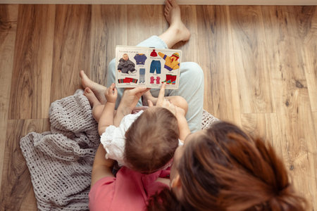 mother and baby reading a book, top view, speech and vocabulary developmentの写真素材
